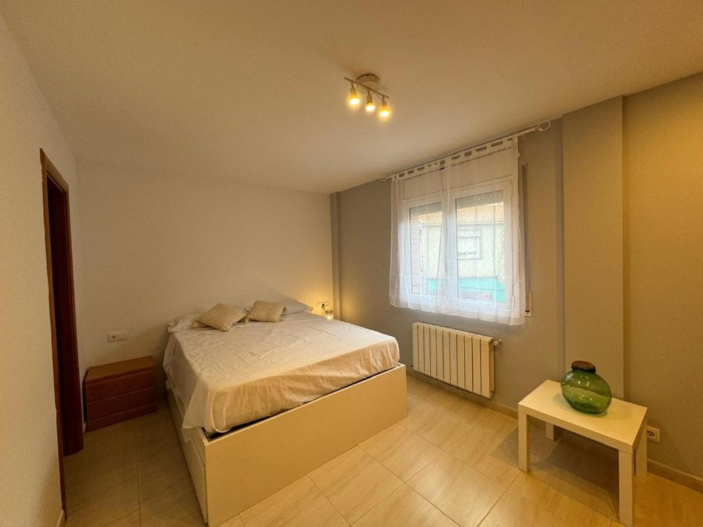 a bedroom with a bed and a window and a table at Costapera in La Pobla de Segur