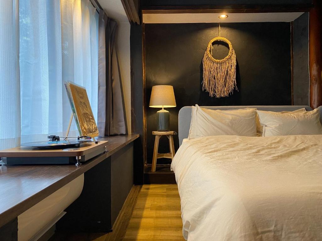 a bedroom with a bed and a desk with a window at Nagasaki Sakayado OKU - Vacation STAY 35113v in Nagasaki