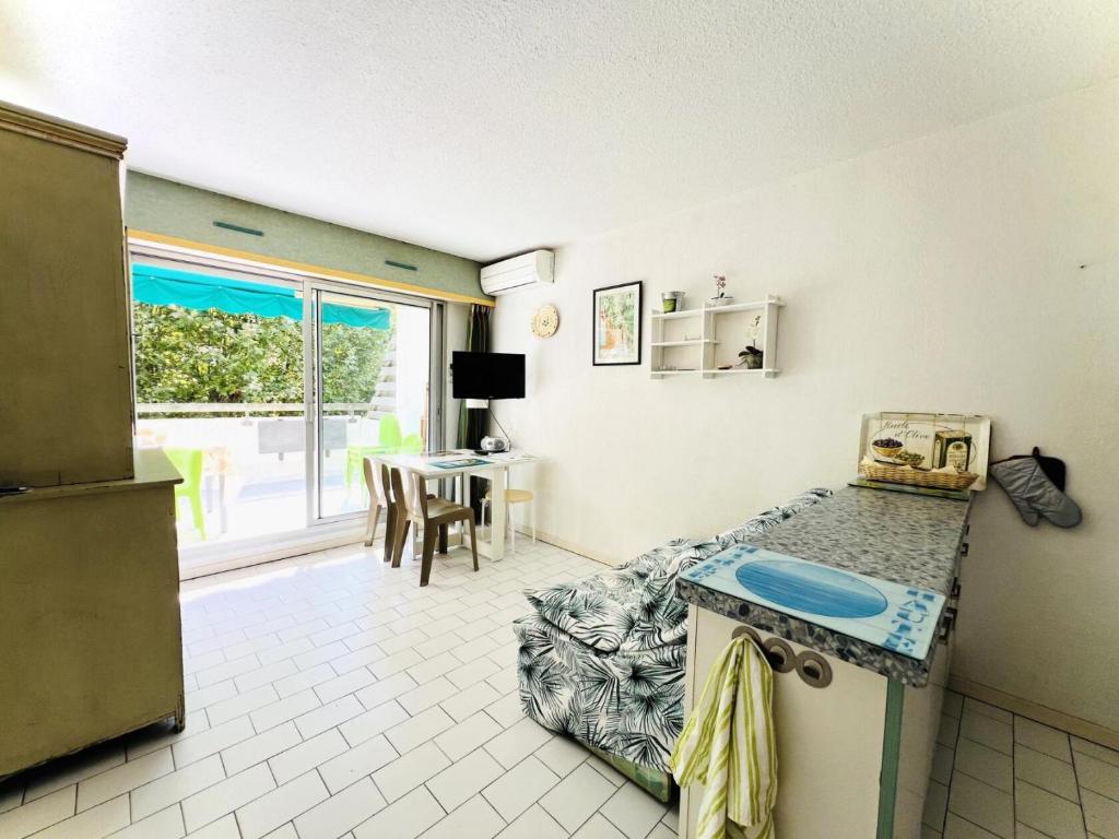 kuchnia z blatem i stołem w pokoju w obiekcie Villegiales Tee1 - Appartement climatisé dans résidence avec piscine MAE-1104 w mieście La Grande-Motte