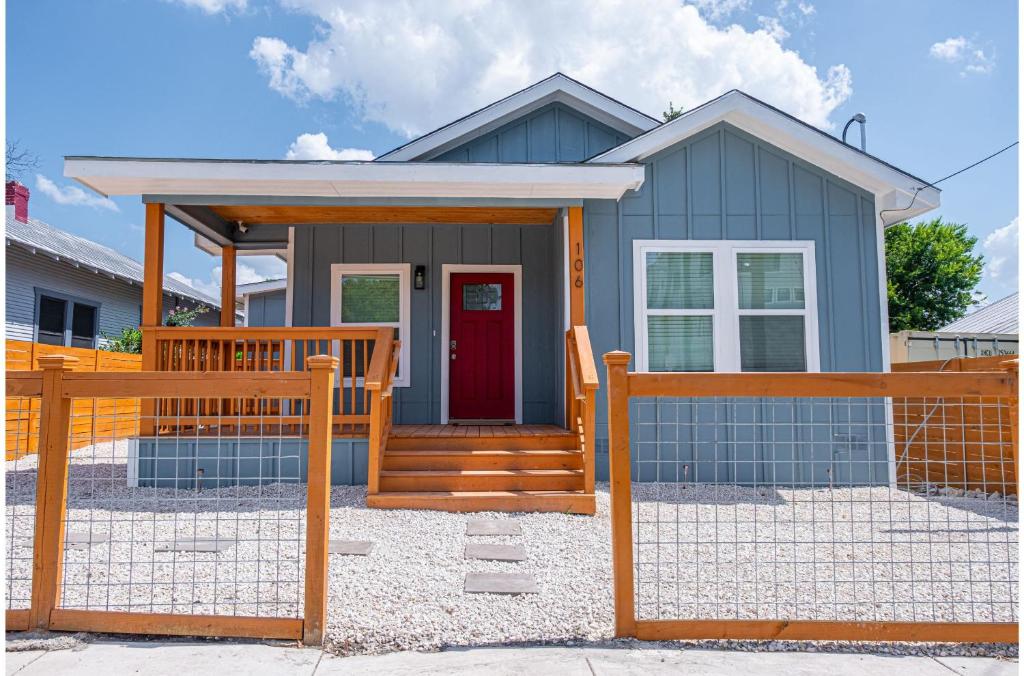 una casa con una puerta roja y una valla de madera en Heaven-sent Convenient 4BR 3BA Near Downtown, en San Antonio