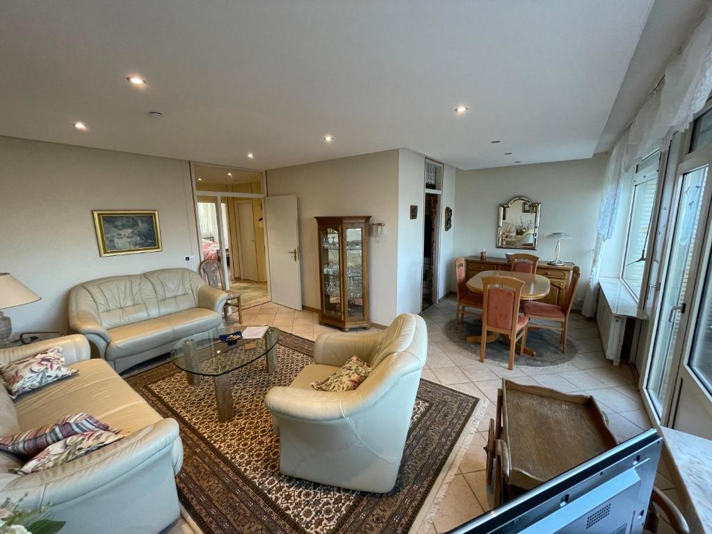 a living room with couches and a dining room at Zentrales Apartment für bis zu 5 Personen mit Balkon, Parkplatz, Waschmaschine & direkten Einkaufsmöglichkeiten in Marl