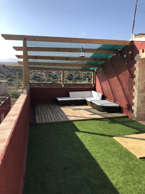 patio z ławkami i trawą na budynku w obiekcie El Cortijillo w mieście Almería