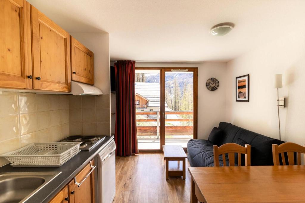 une cuisine et un salon avec un canapé et une table dans l'établissement Les Chalets De Bois MÉan - D - Appartement sur les hauteurs des Orres 1800 MAE-3211, aux Orres