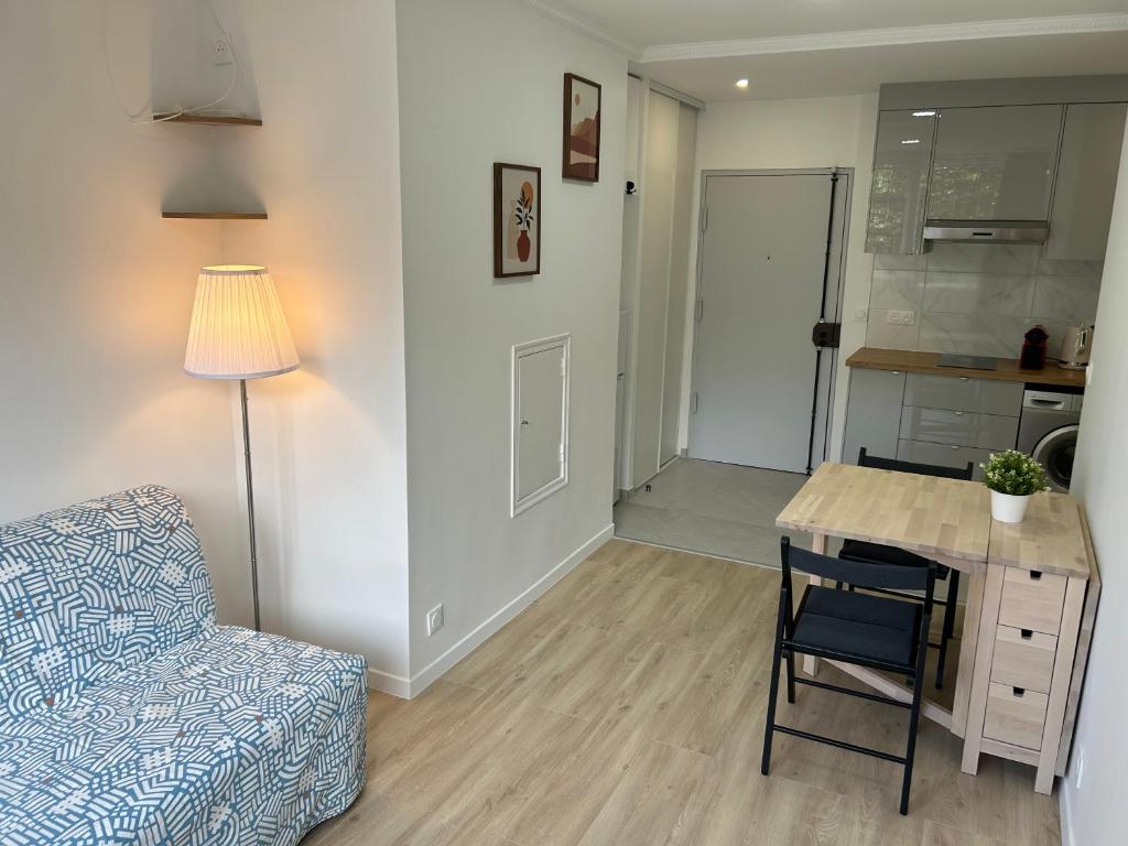 - un salon avec un canapé et une table avec une chaise dans l'établissement Charmant Appartement au Cœur du 13ème Arrondissement de Paris, à Paris