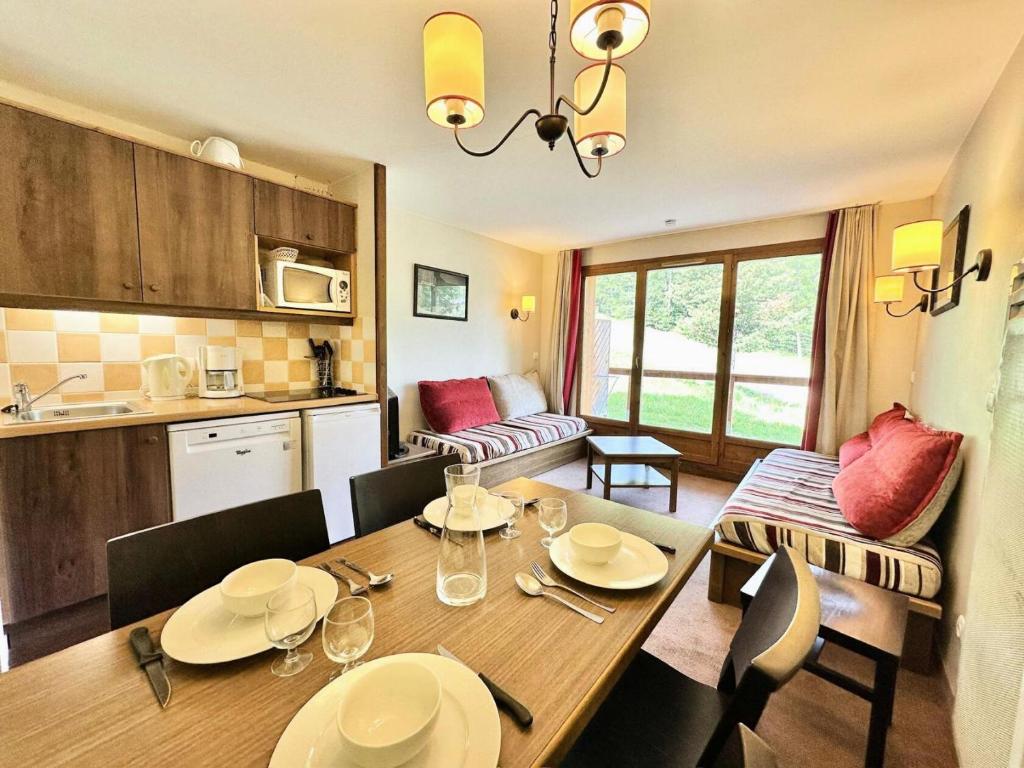 une cuisine et une salle à manger avec une table et des chaises dans l'établissement Résidence L'albane - L'ALBANE - PARTIR DEPUIS LA TERRASSE EN SKIS MAE-4531, à Vars
