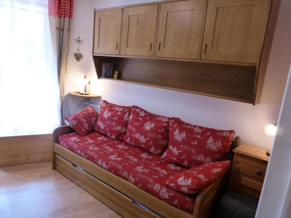 - un canapé avec des oreillers rouges dans le salon dans l'établissement Résidence Pierres Blanches - Pierres Blanches F392 MAE-9901, aux Contamines-Montjoie