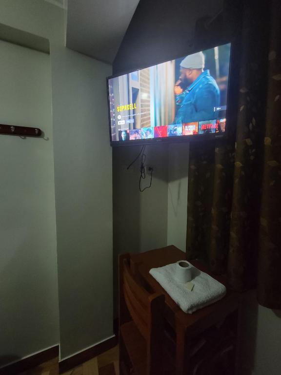 Un televisor de pantalla plana en la pared de una habitación. en Hospedaje Escorpio, en Lima