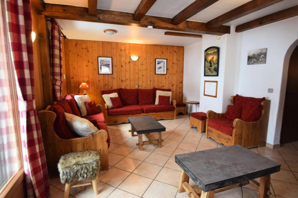 un salon avec des canapés rouges et une table dans l'établissement Chalet Le Becoin - CHALET MITOYEN 10/12 pers - 100m des pistes SAUNA- WIFI - PLAGNE 1800 MAE-6654, à Aime La Plagne