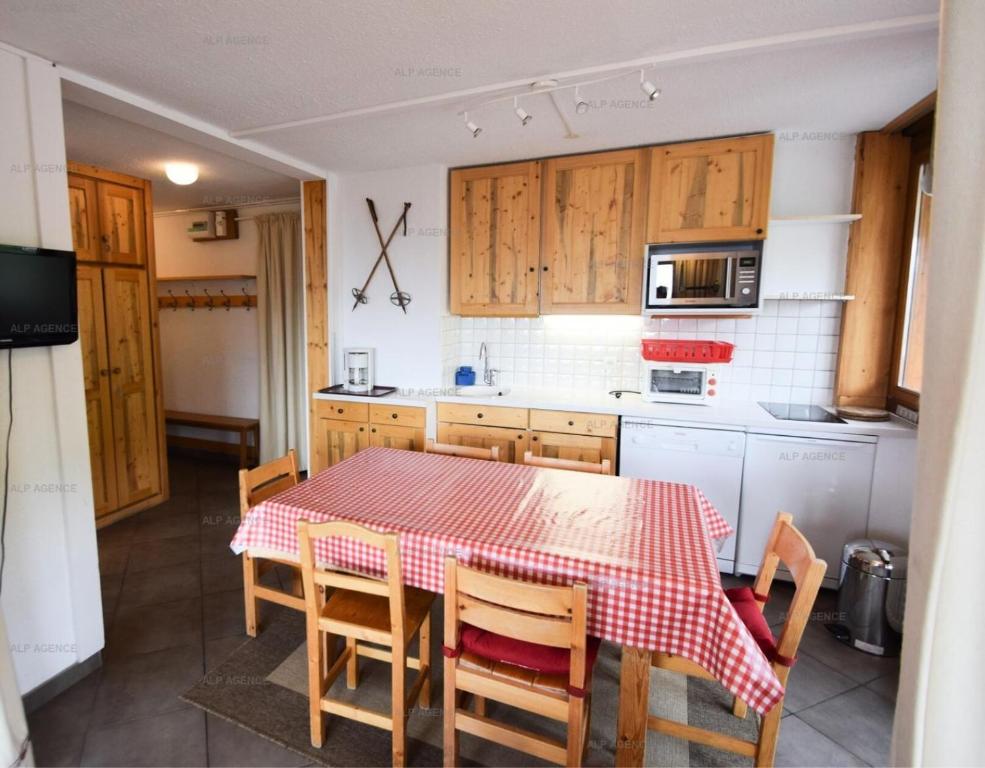 une cuisine avec une table et des chaises rouges et blanches dans l'établissement Résidence L'everest - 2 Pièces 5 pers - L'EVEREST - PLAGNE CENTRE MAE-5814, à Aime La Plagne