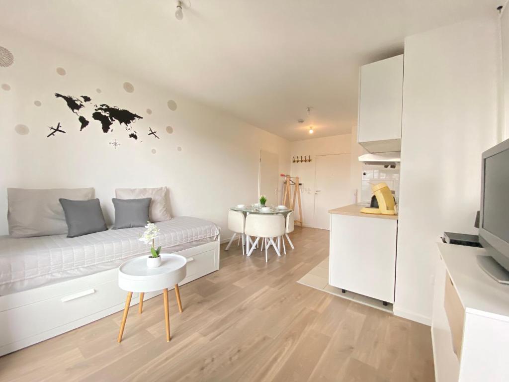 un salon avec un lit et une cuisine dans l'établissement Grand Studio Montévrain - Disneyland RER A, à Montévrain