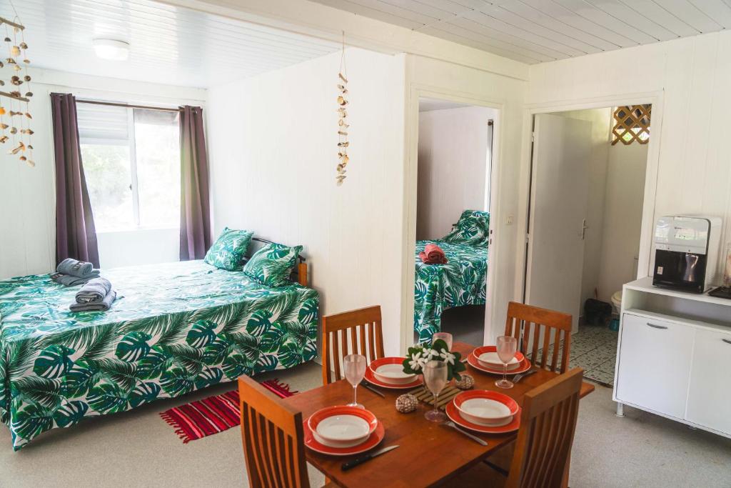 a living room with a table and a bed at Kinakamo Lodge et Activités Rangiroa in Tiputa