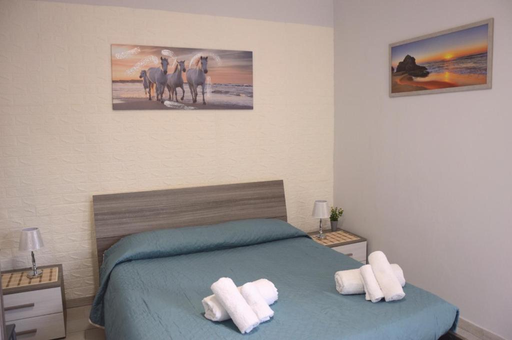 a bedroom with a bed with two white towels at Spiaggia LazzarettoHouse in Alghero