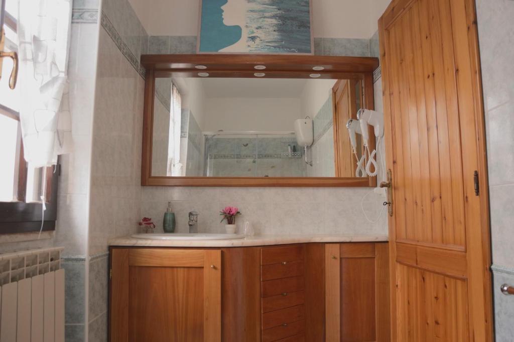 a bathroom with a sink and a mirror at Spiaggia LazzarettoHouse in Alghero