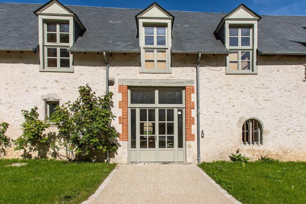 a large white house with a door and grass at Château de Conon gîte l'Orangerie in Cellettes