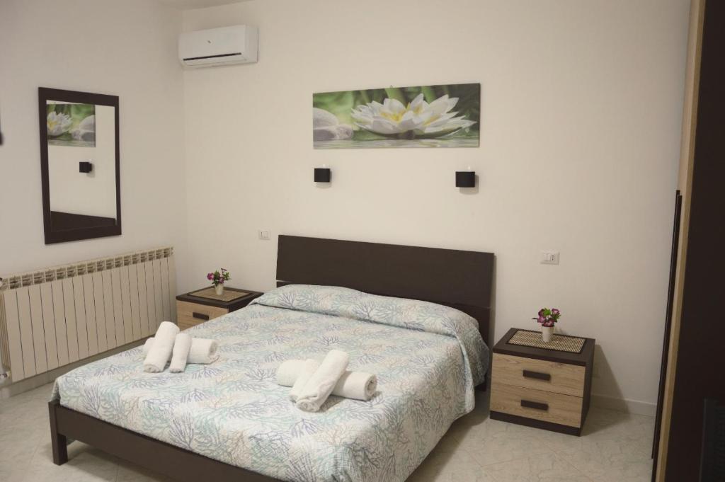 a bedroom with a bed with two night stands and two tables at Spiaggia LazzarettoHouse in Alghero
