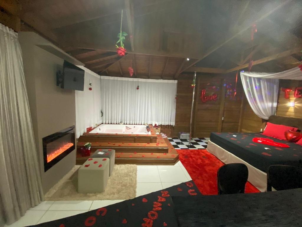 a bedroom with two beds and a tv in it at Cabana Dois Amores. Destino romântico. in Barracão