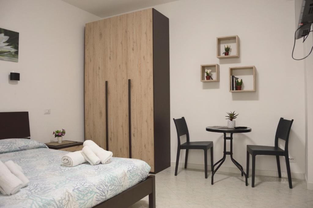 a bedroom with a bed and a table and chairs at Spiaggia LazzarettoHouse in Alghero