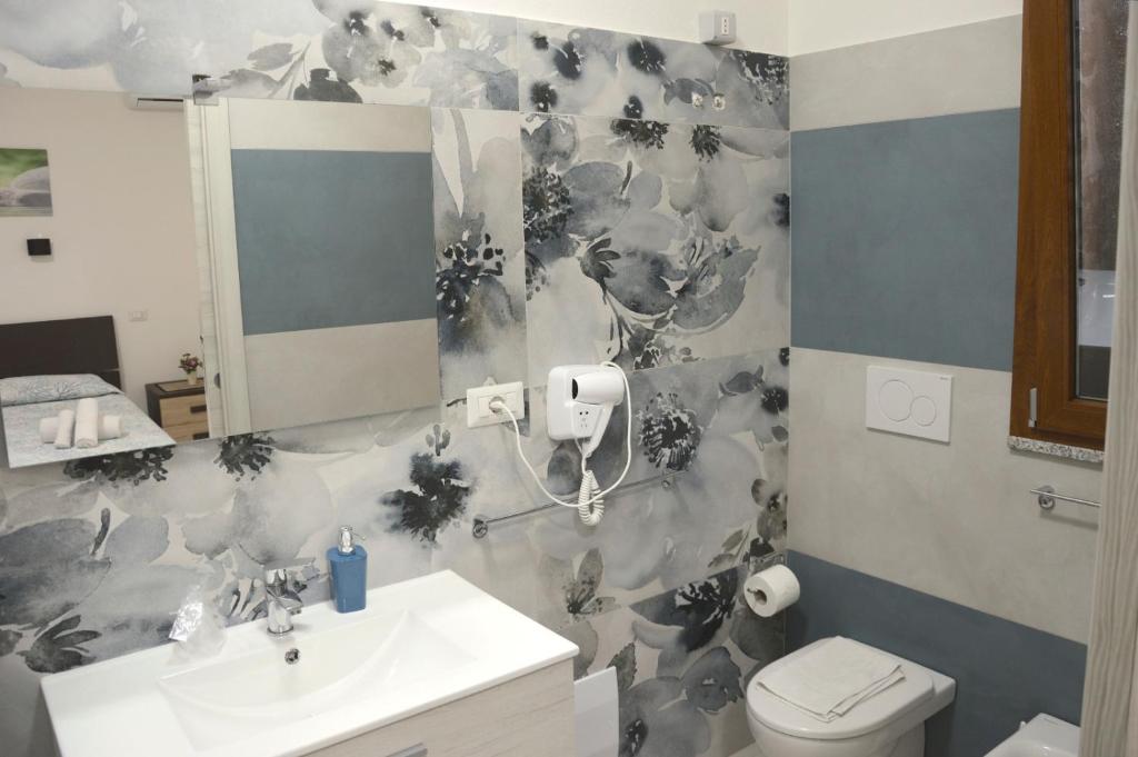 a bathroom with a white sink and a toilet at Spiaggia LazzarettoHouse in Alghero
