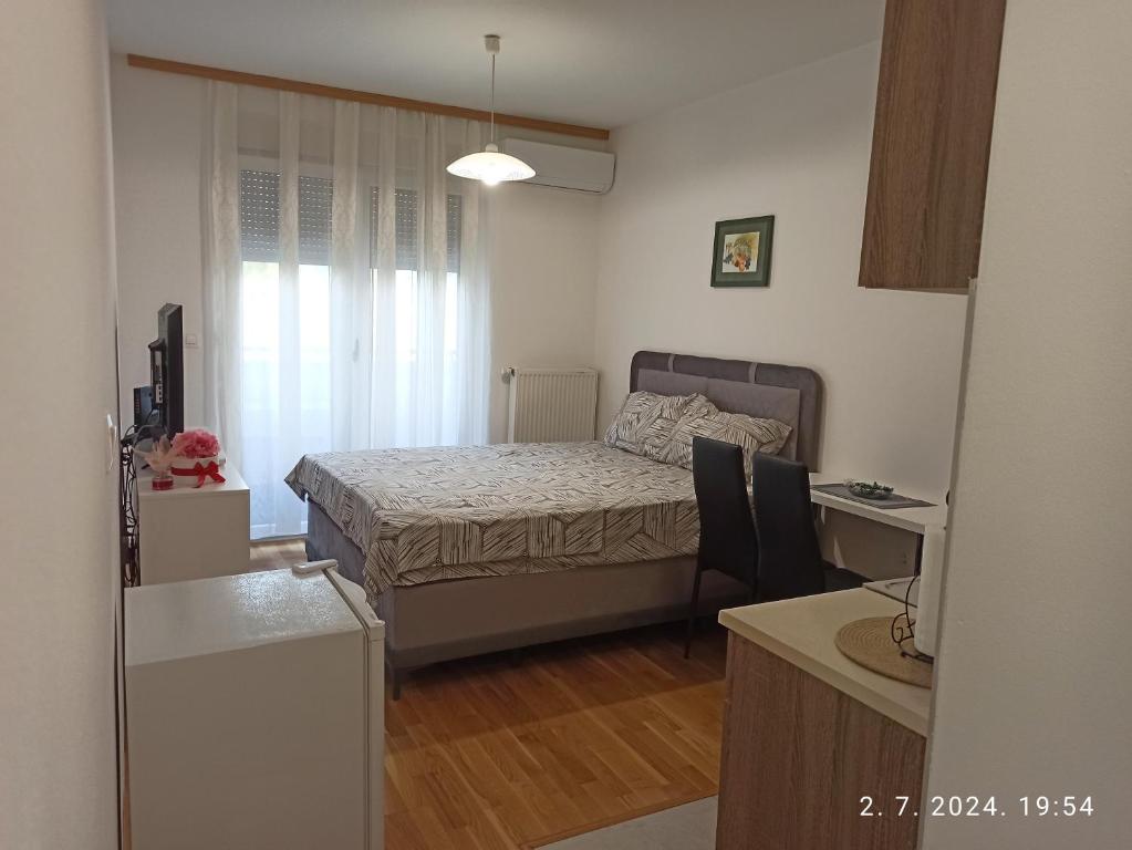多博伊Apartman Oaza的一间带床和书桌的小卧室