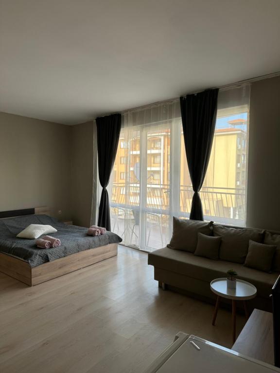 a living room with a bed and a couch at Студио Мая in Sunny Beach