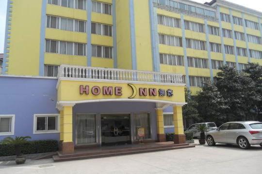 a large yellow and blue building with a home inn sign at Home Inn Wuhan Gaoxiong Road in Wuhan