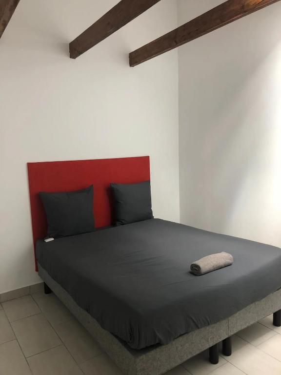 un lit avec tête de lit rouge dans une chambre dans l'établissement Spacieux T2, à Colombes