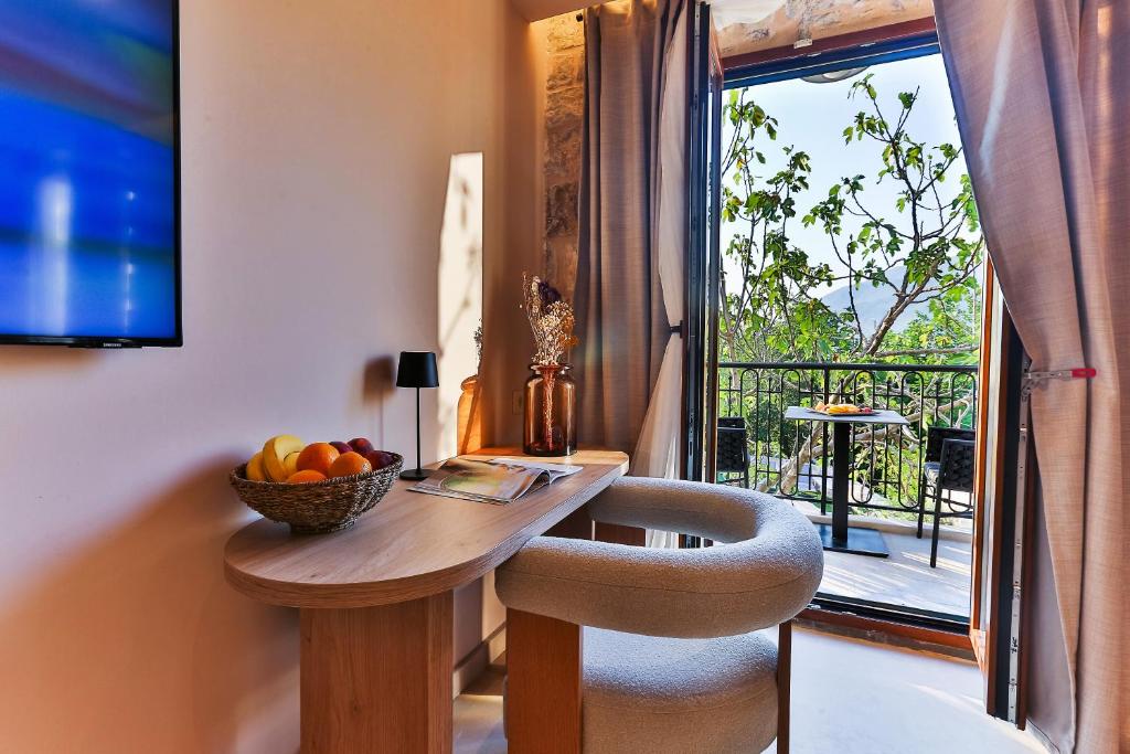 a room with a table with a bowl of fruit and a window at Boutique hotel Ruzmarin SPA & Garden by Aycon in Budva
