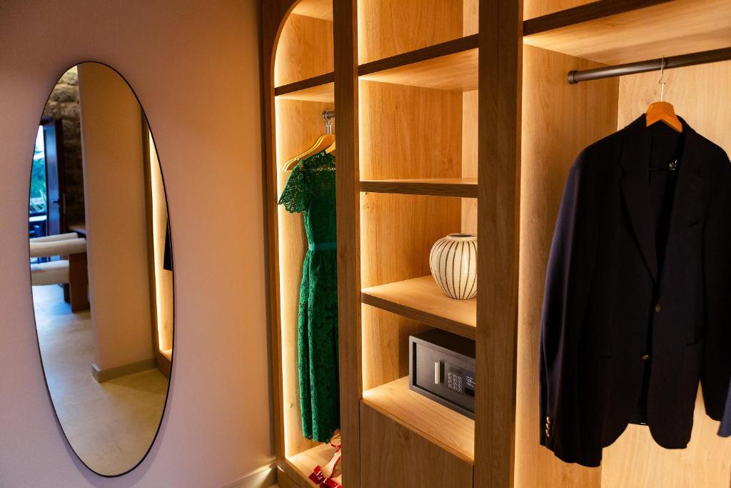 a dressing room with a mirror and a robe at Boutique hotel Ruzmarin SPA & Garden by Aycon in Budva