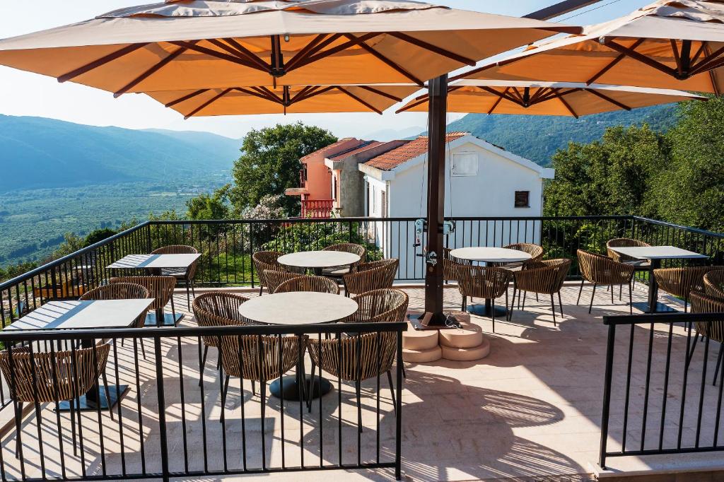 an outdoor patio with tables and chairs and umbrellas at Boutique hotel Ruzmarin SPA & Garden by Aycon in Budva