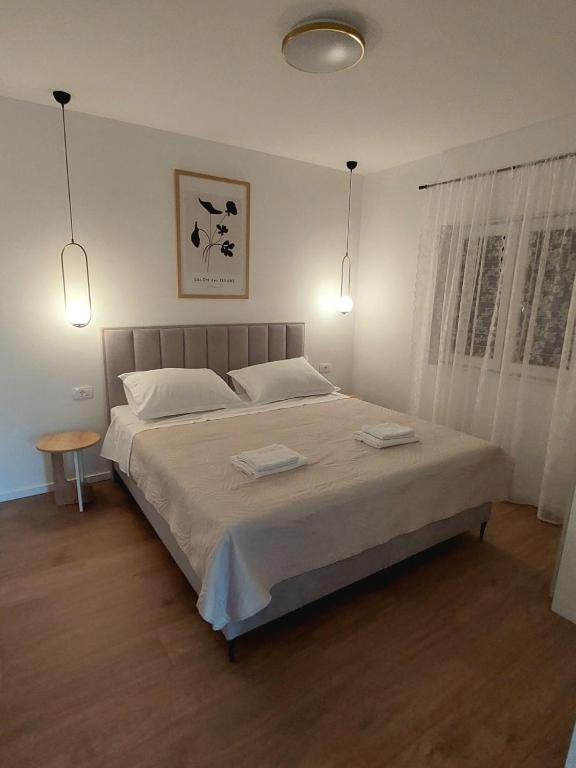 a bedroom with a large bed with two white pillows at Apartman Villeto in Stari Grad
