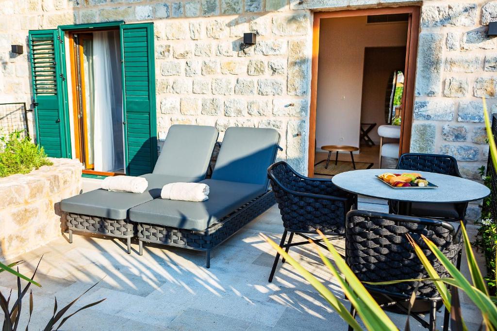 a patio with two chairs and a table and a table at Boutique hotel Ruzmarin SPA & Garden by Aycon in Budva