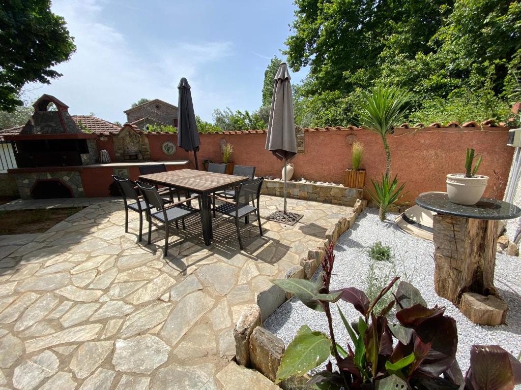a patio with a table and chairs and umbrellas at Accommodation Villa Mallis in Chorto, Pelion in Chorto