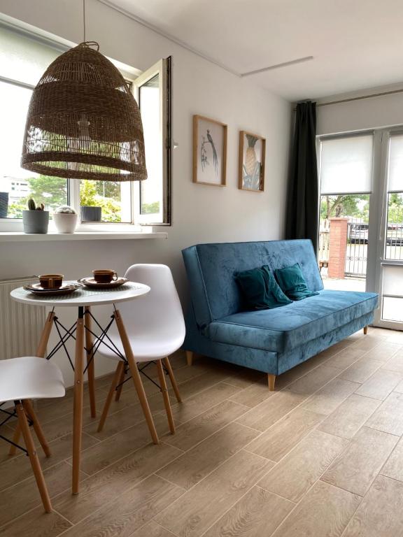 a living room with a blue couch and a table at Pokoje blisko morza in Sarbinowo