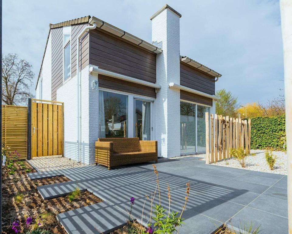 a house with a couch sitting on a patio at Veermansplaat 27 - Noordzeepark Ouddorp in Ouddorp