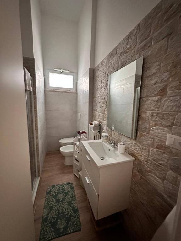 un bagno con lavandino, WC e specchio di La Rosa di Candy a Brindisi