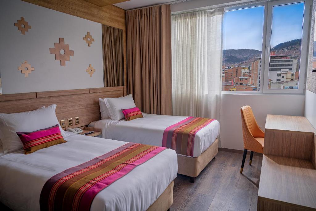 ラパスにあるIllampu Art Boutique Hotelのベッドが2つと窓があるホテルの部屋