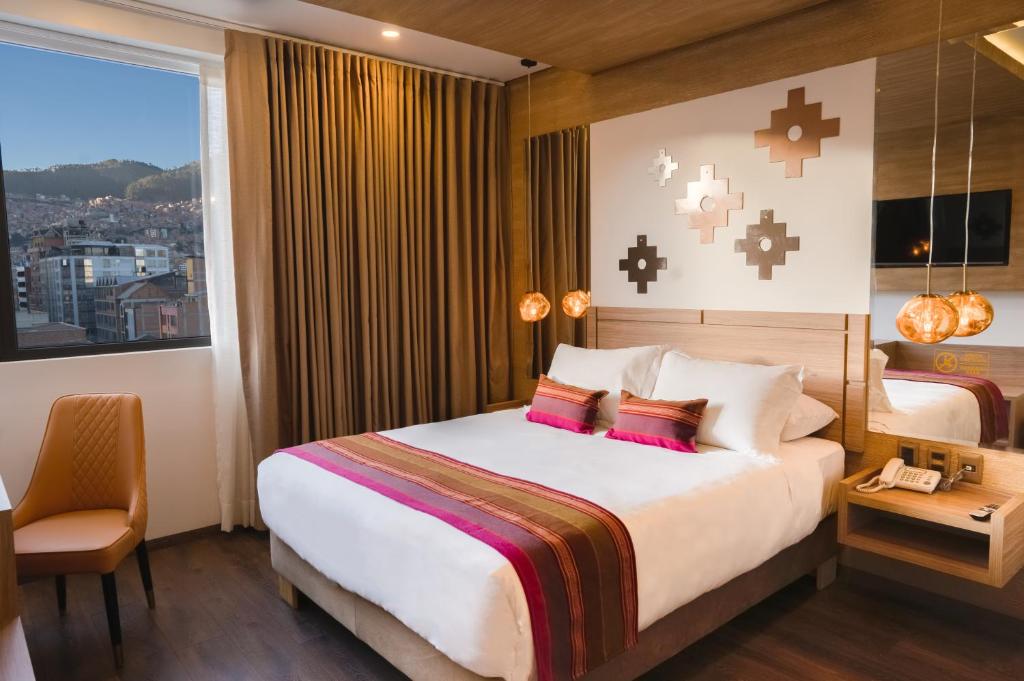 ラパスにあるIllampu Art Boutique Hotelの大きなベッドと窓のあるホテルの部屋