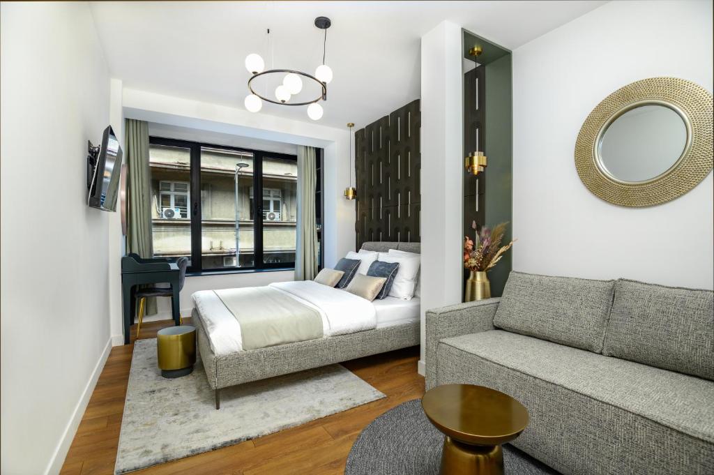 a bedroom with a bed and a couch at URBAN DOWNTOWN luxury rooms and suites in Belgrade