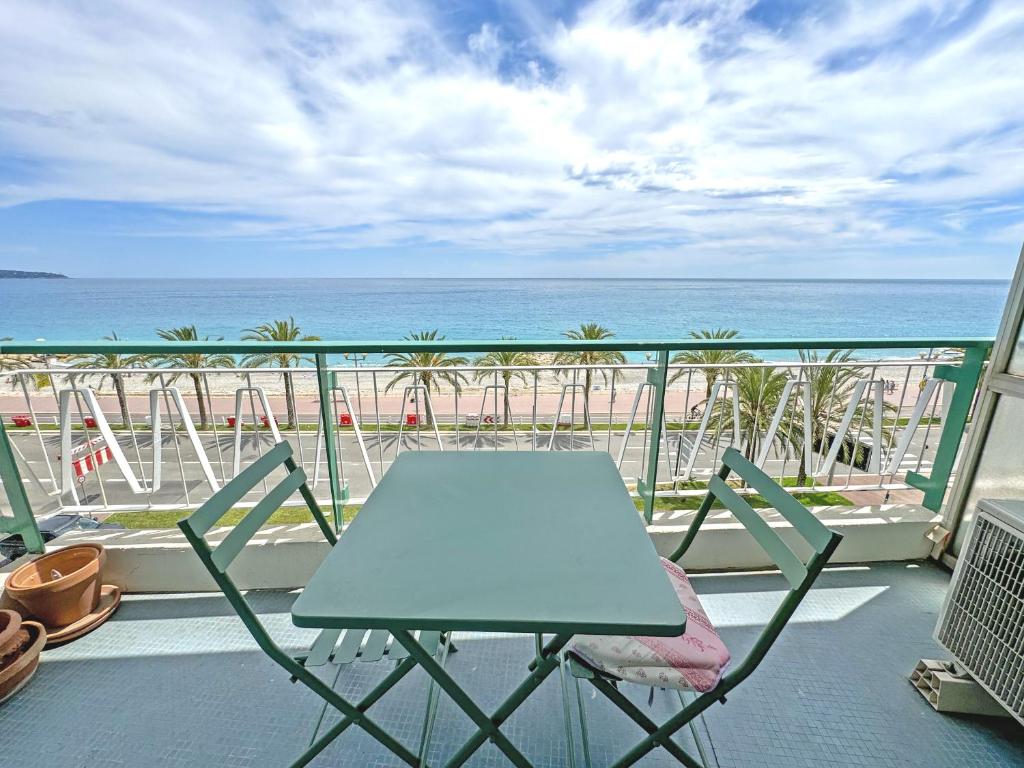 une table et des chaises sur un balcon avec la plage dans l'établissement Milord Promenade 4, à Nice