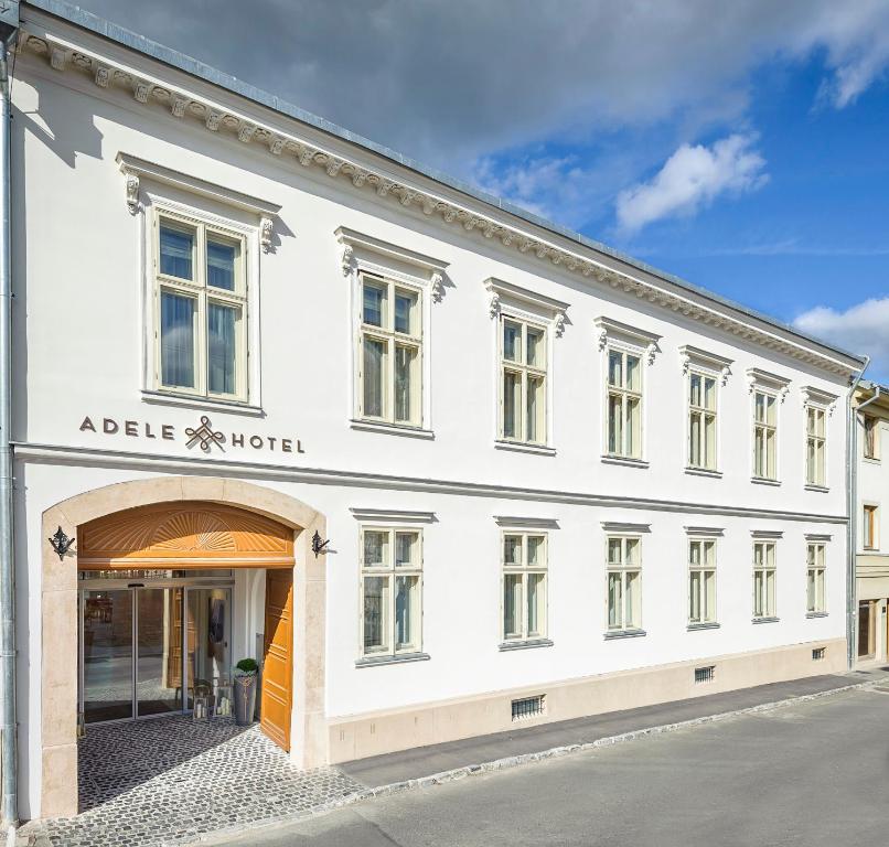 a large white building with a large window at Adele Boutique Hotel in Pécs