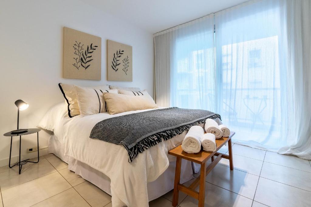Una habitación blanca con una cama y una ventana en Moderno y cálido estudio en Recoleta, en Buenos Aires