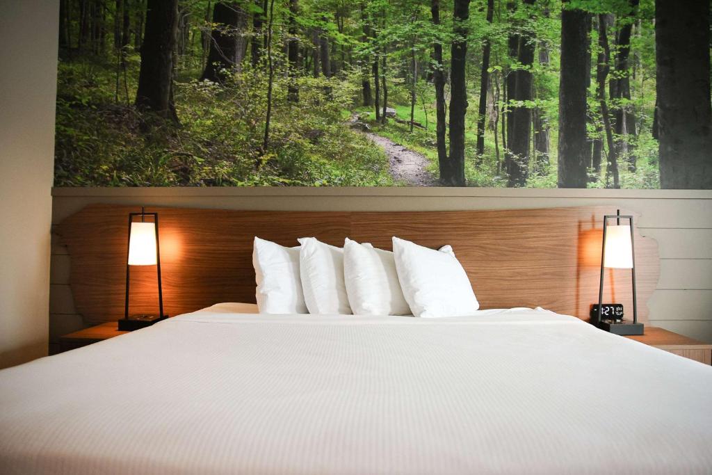 a bedroom with a large white bed with two lamps at The Inn At Tree City, BW Signature Collection in McMinnville