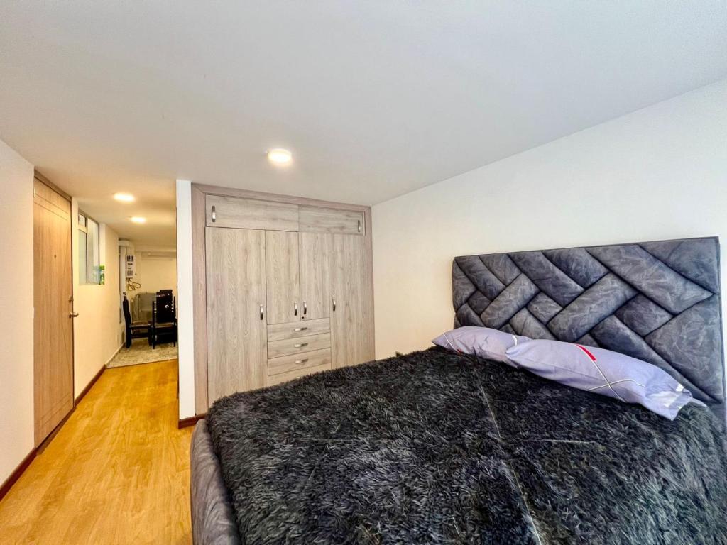 une chambre avec un grand lit dans une pièce dans l'établissement aparta estudio de lujo, à Pasto
