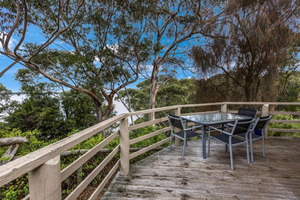 a table and chairs sitting on a wooden deck at Jetty View - Rosella Cabin in Nungurner