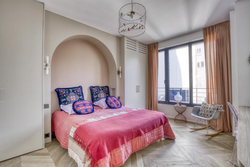 une chambre avec un lit et une grande fenêtre dans l'établissement AMAZING PLACE PARIS 4 IN THE OLD Paris, à Paris