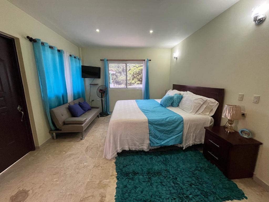 una camera con letto, divano e finestra di Beach Apartment on Samana Bay with Pool, AC, Fast Wi-Fi, Walk to Beach & River, Whale Watching, Near Salto El Limón a Santa Bárbara de Samaná