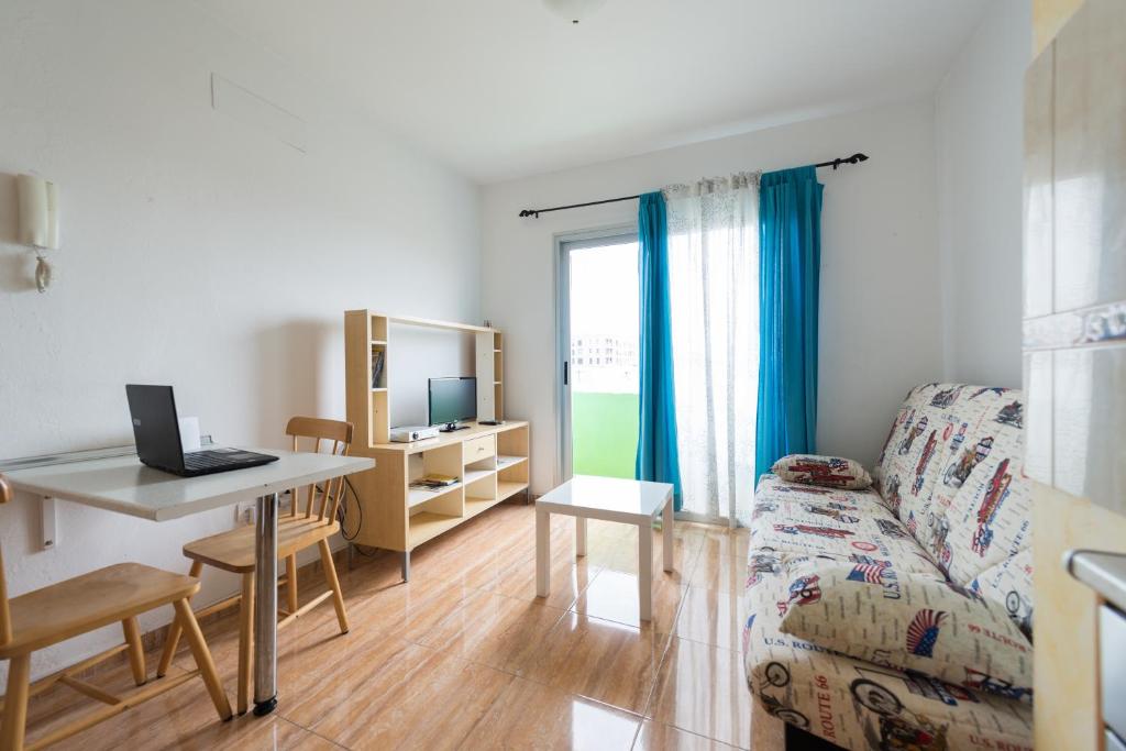 a living room with a desk and a table with a laptop at Apartamento Faycan in Vecindario