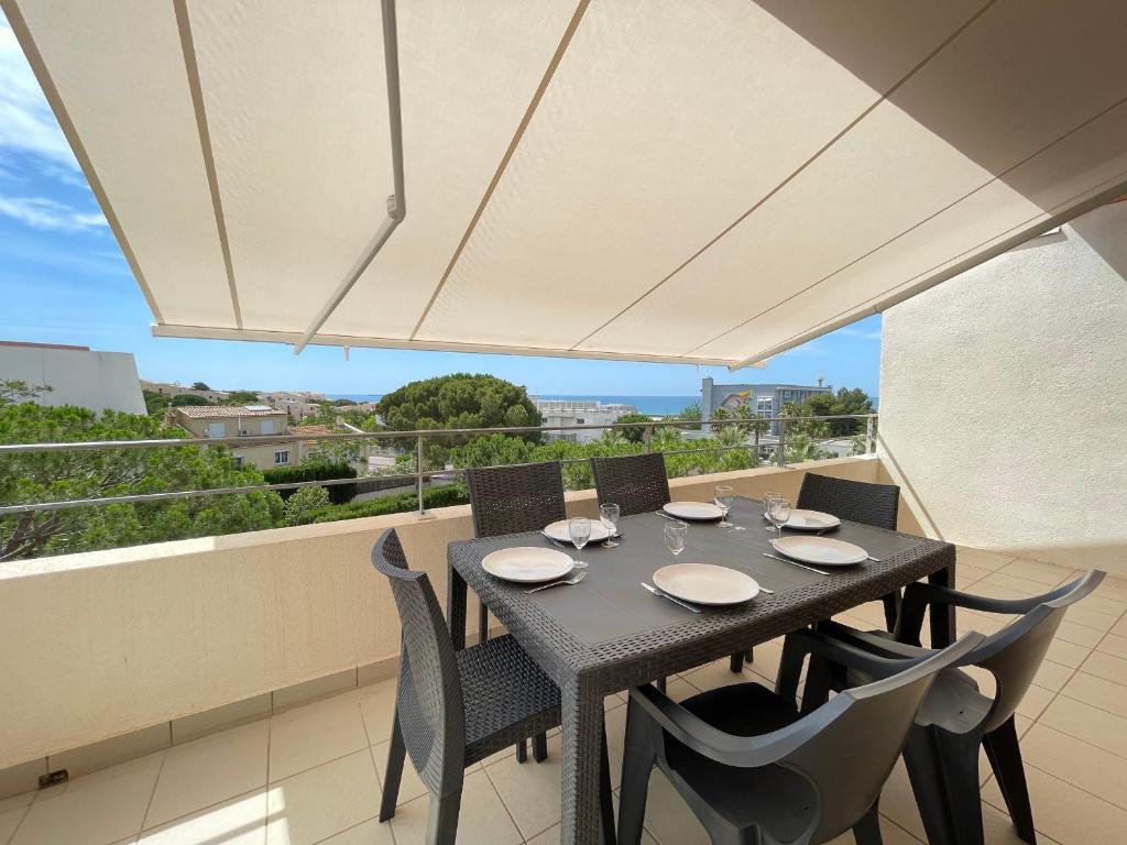 une table et des chaises sur un balcon avec vue dans l'établissement Bel Appartement T4 à Sète avec Terrasse, Climatisation et Parking Privé - FR-1-338-571, à Sète