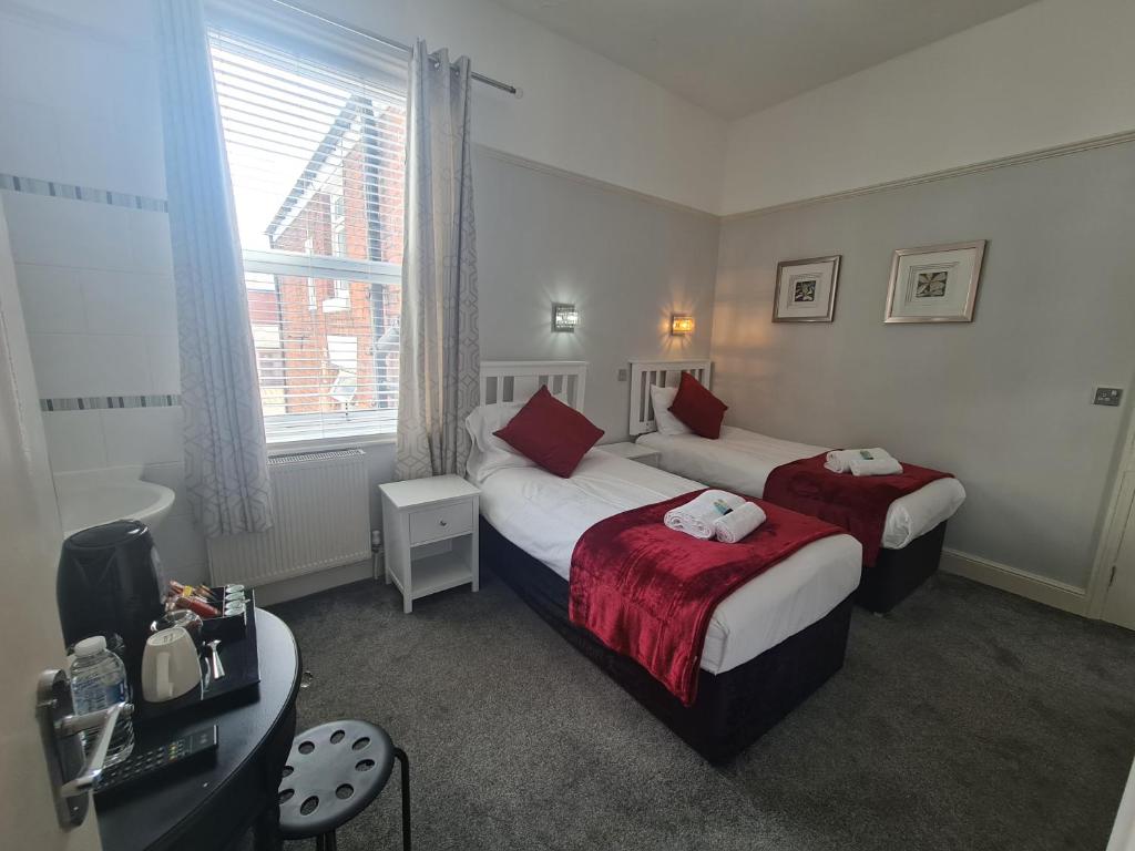 a hotel room with two beds and a window at Clifton Villa - Southport in Southport