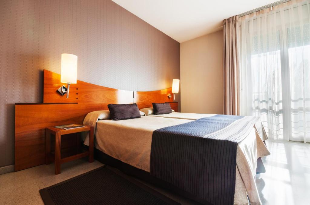 ein Hotelzimmer mit einem Bett und einem Fenster in der Unterkunft Hotel Granollers in Granollers